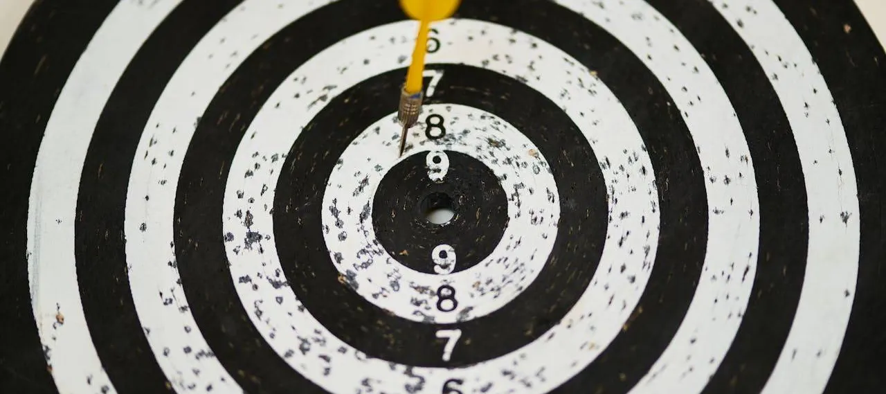 Yellow dart near the bullseye of a black-and-white target.